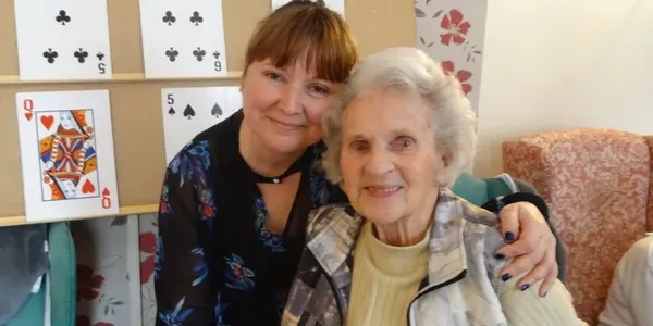 A resident playing cards with a member of the team